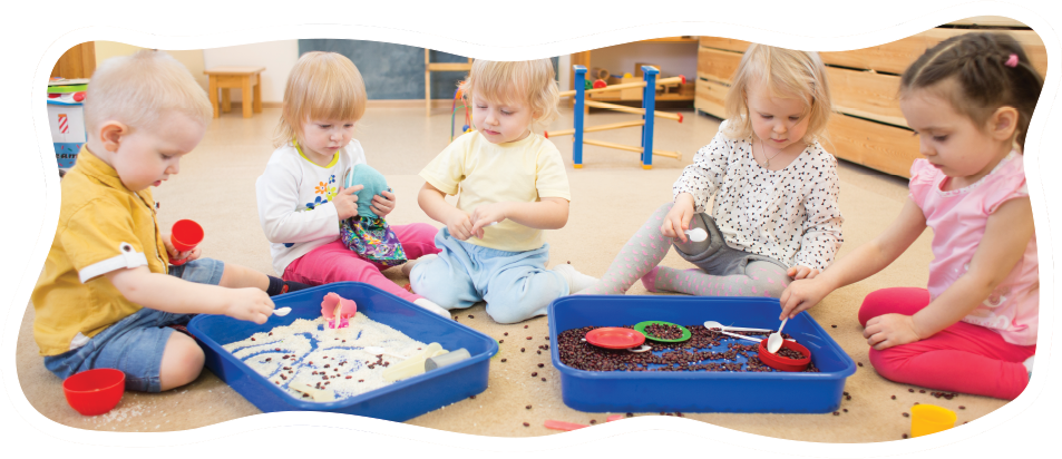 group of preschoolers playing in sensory bins